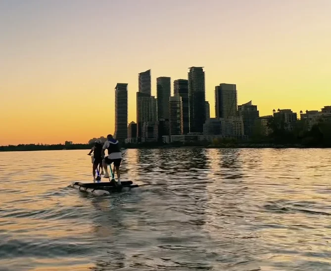 A shared water-bike ride at sunset with the Abu Dhabi skyline ahead